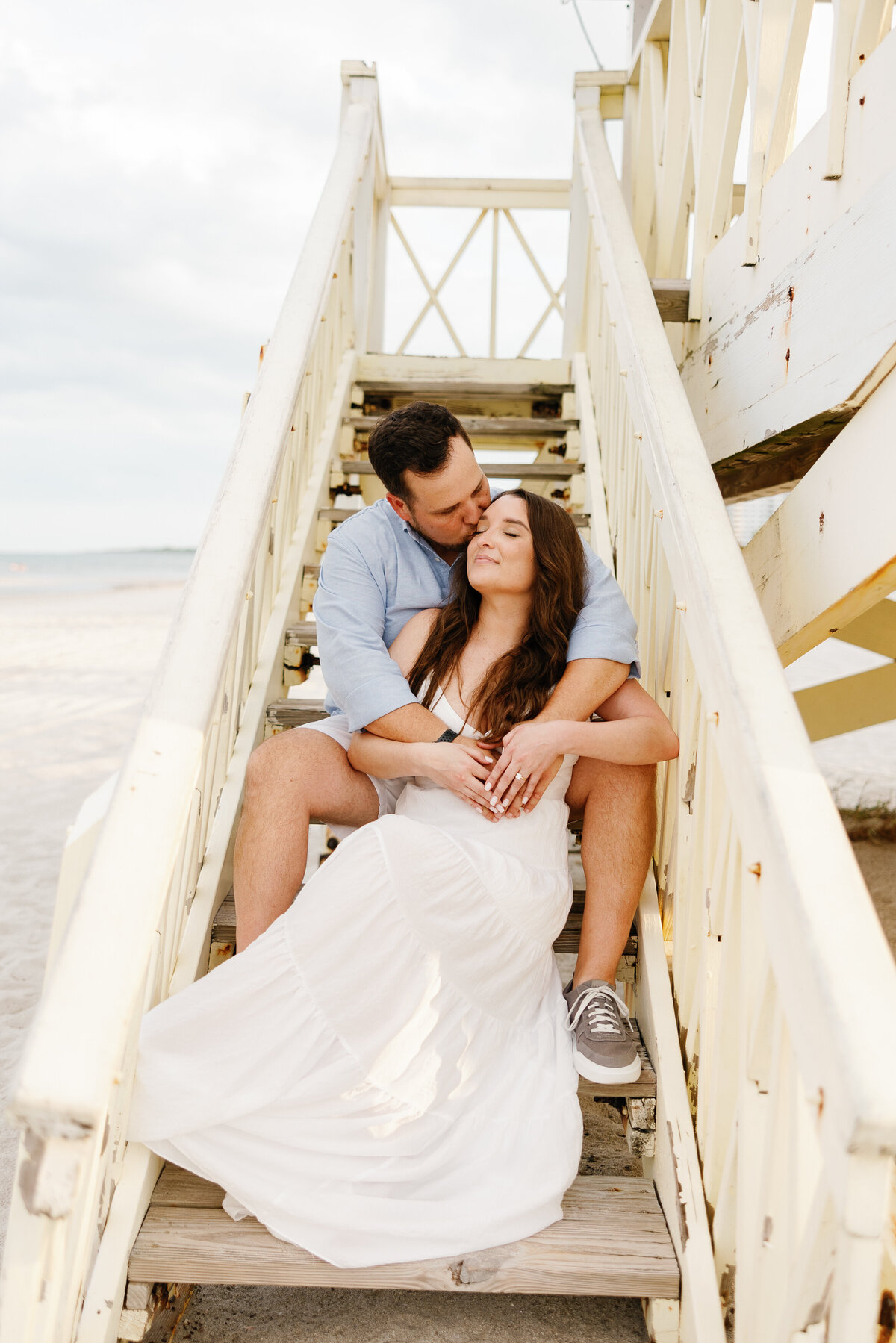 Couple sitting on a staircase, photographed by Miami wedding photographer Claudia Amalia, illustrating her engagement photography services.