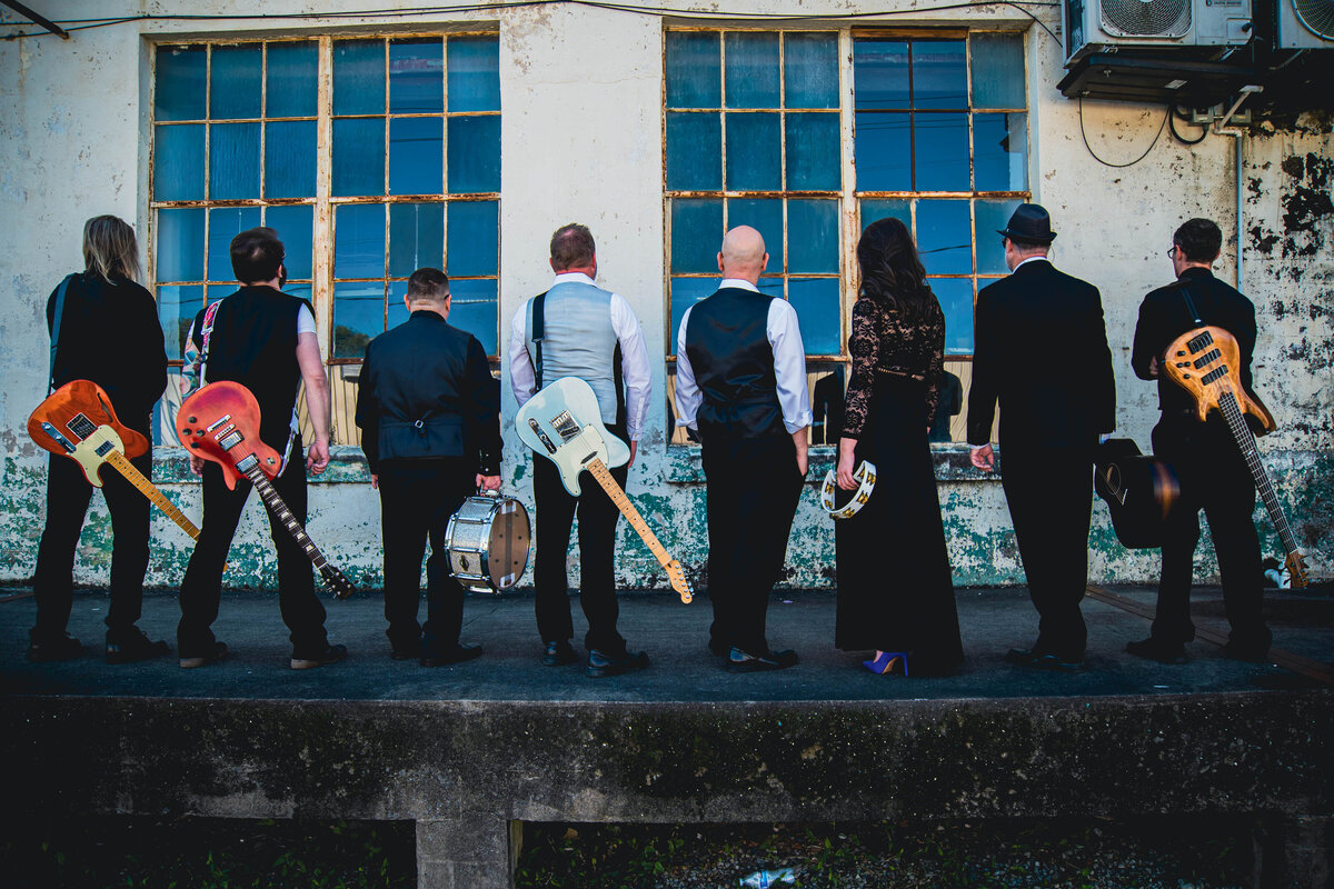 View from behind of a band holding their instruments 
