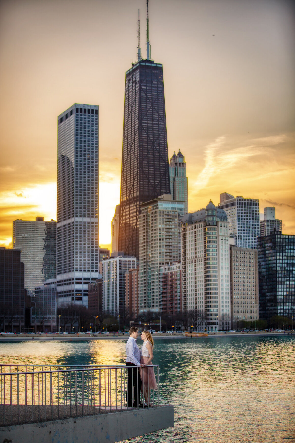 A sunset engagement photo that shows the Chicago skyline in the background at Olive Park.