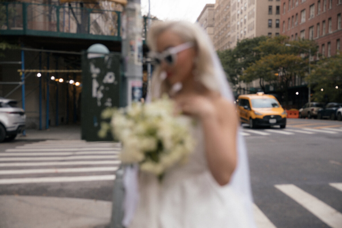 Close-up shot of the bride’s bouquet with NYC streets softly blurred in the background.