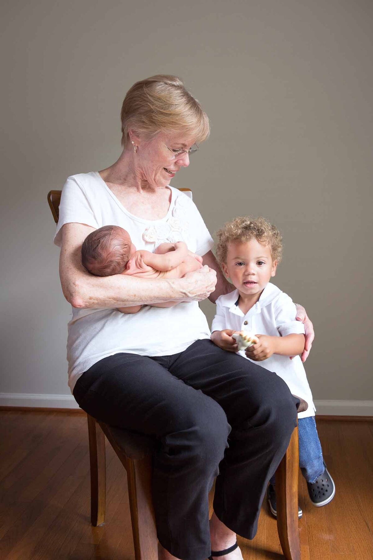 Grandmother holding newborn grandson while looking at older grandson in Columbia, SC