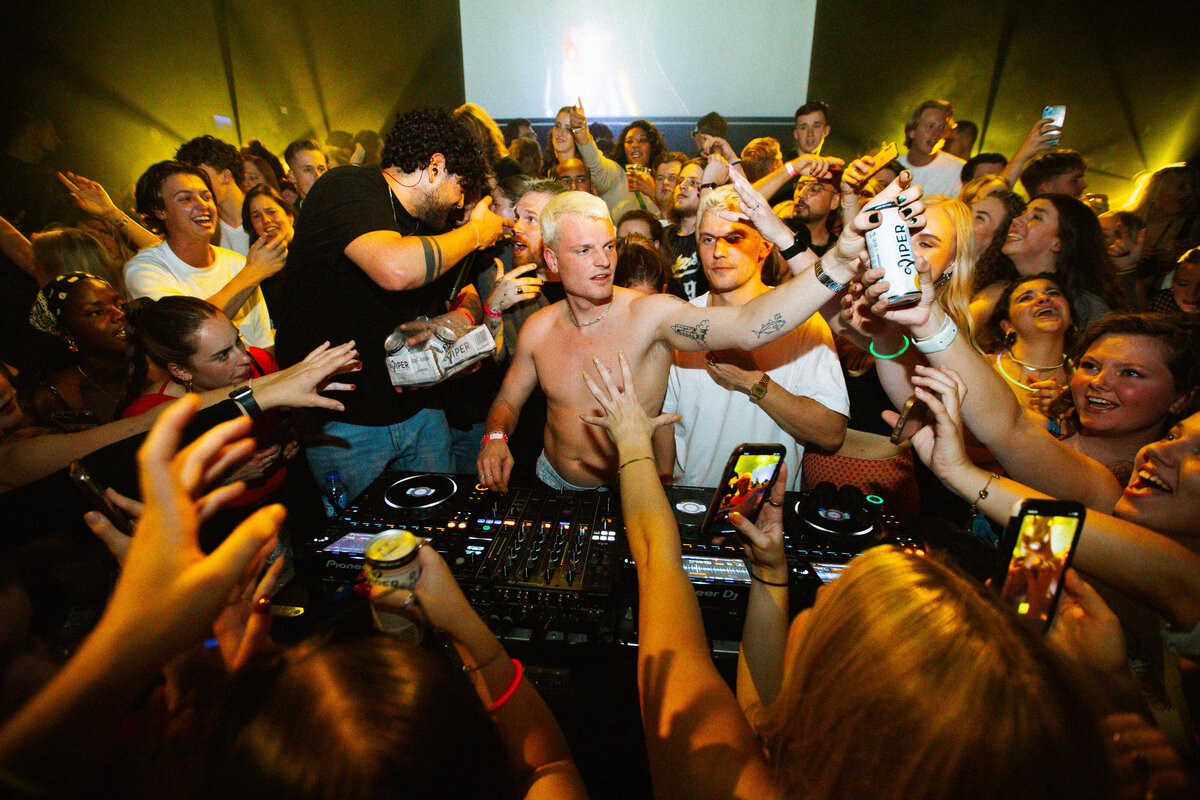 Bo Eppink captures the high-energy atmosphere as fans crowd around Sam Hofman during his festival set.