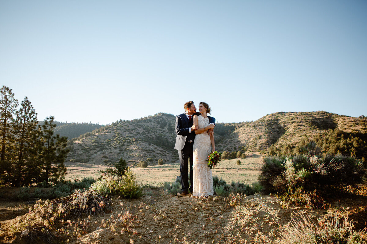 Ali and Brian hold one another with mountains behind them.