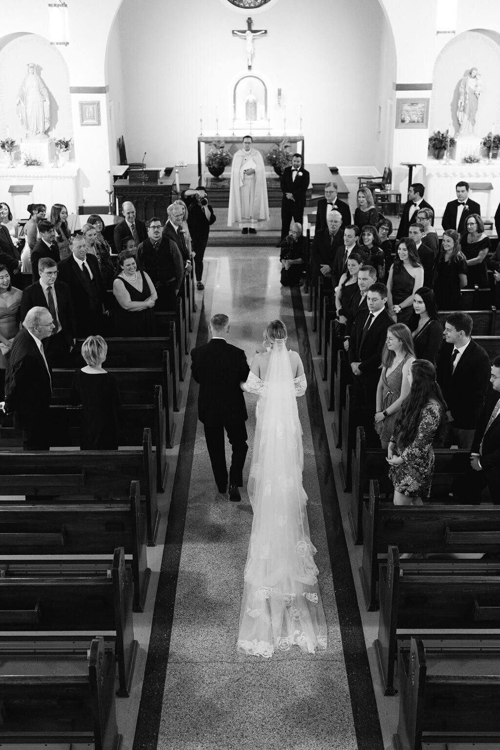 Dramatic black and white image of a bride being walked down her aisle by her father in a Georgetown Catholic Church.