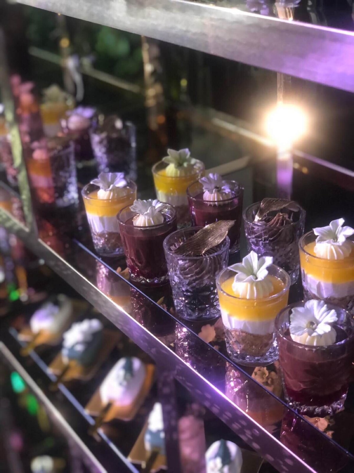 Mousse desserts on a mirrored shelf