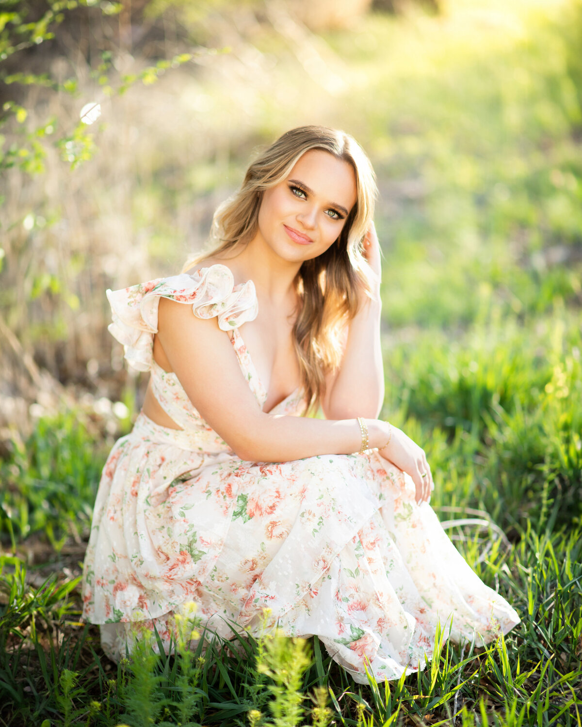 senior portrait in a dress during golden hour outside in a grassy field