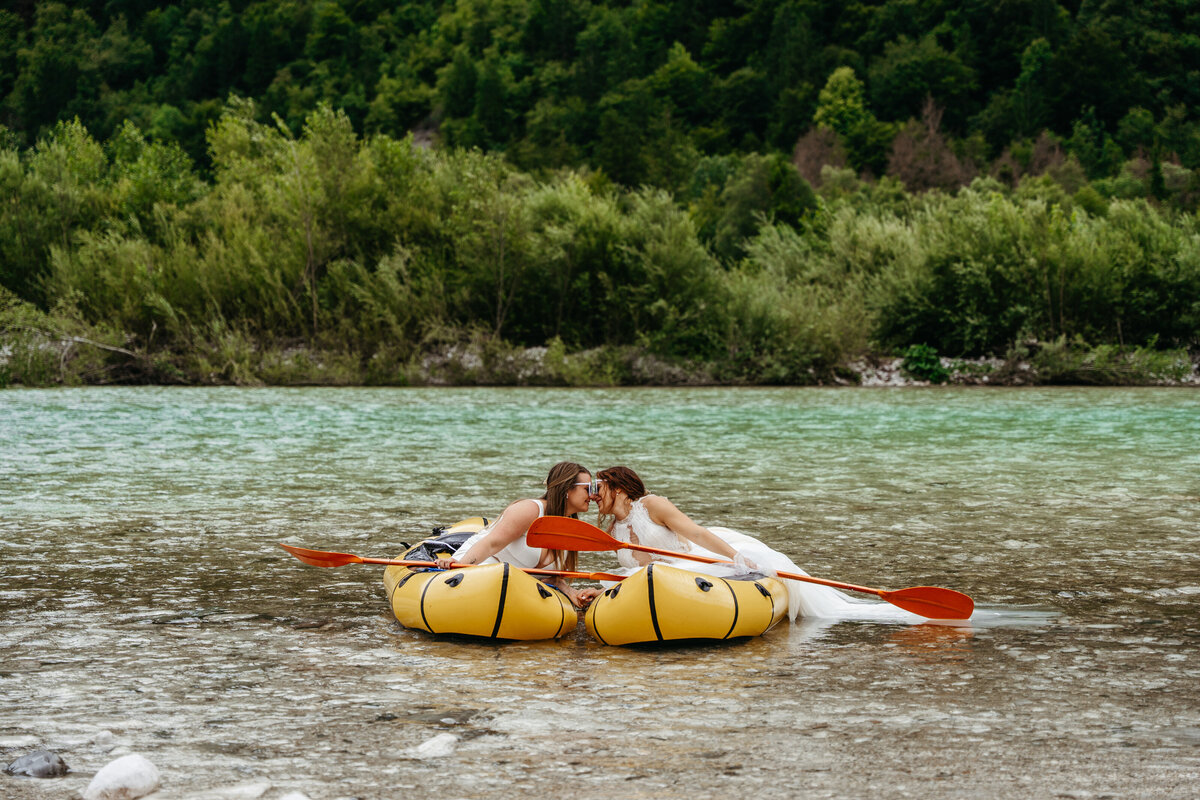 lesbian brides in yellow packraft in Soča Valley river elopement