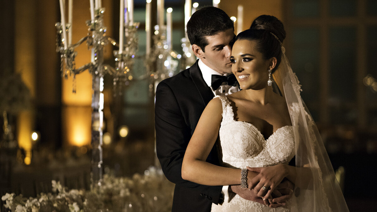 A romantic moment between the bride and groom at an elegant, candle-lit wedding reception, captured by Rodrigo Varela Photography."