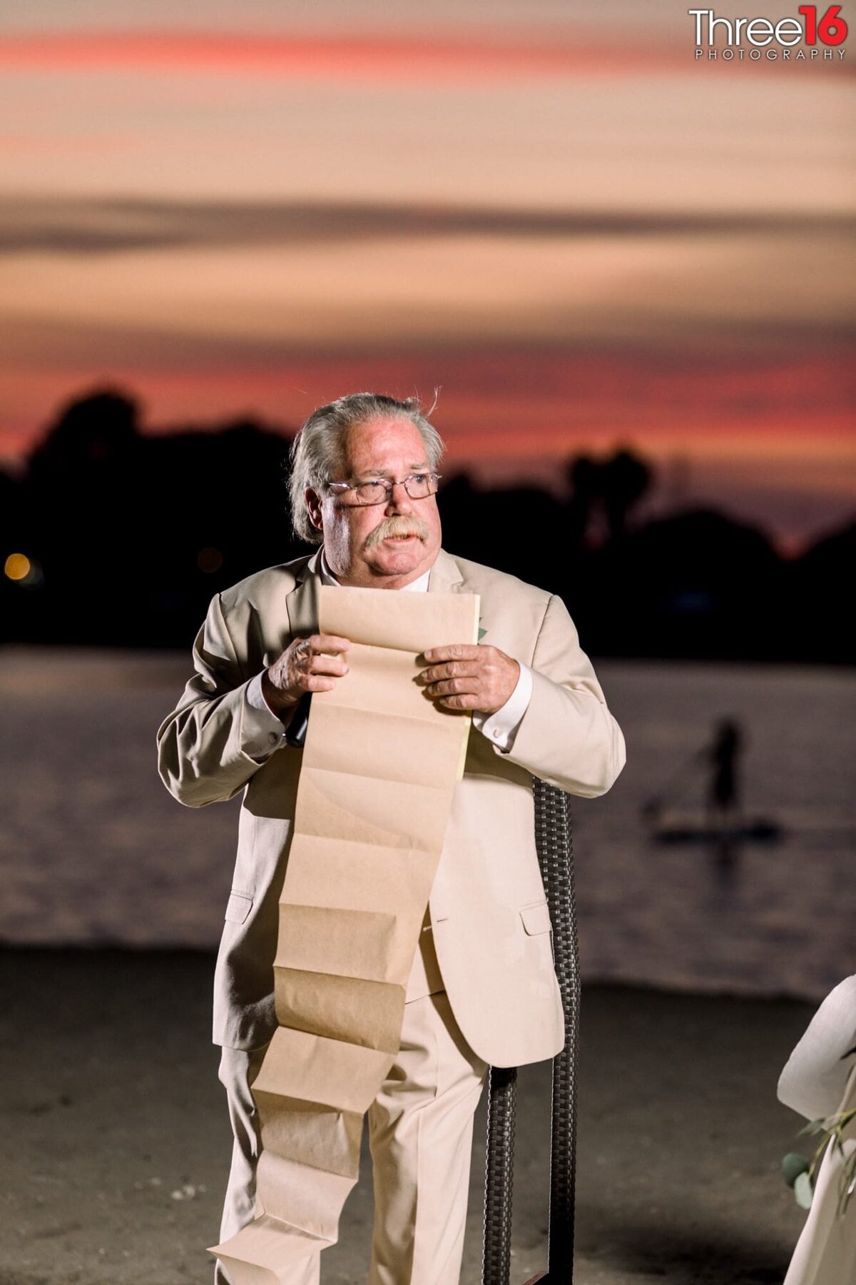 Father of the Bride reads off a long list during his toast to the couple