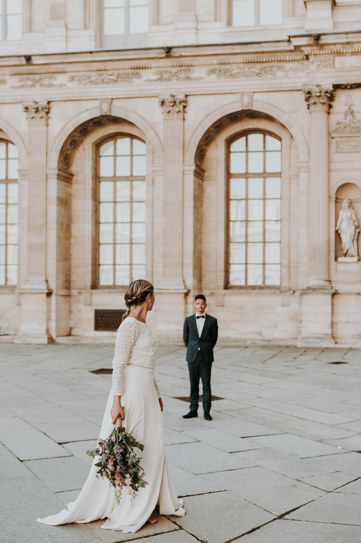 Bruidspaar staat statig op plein in Parijs.