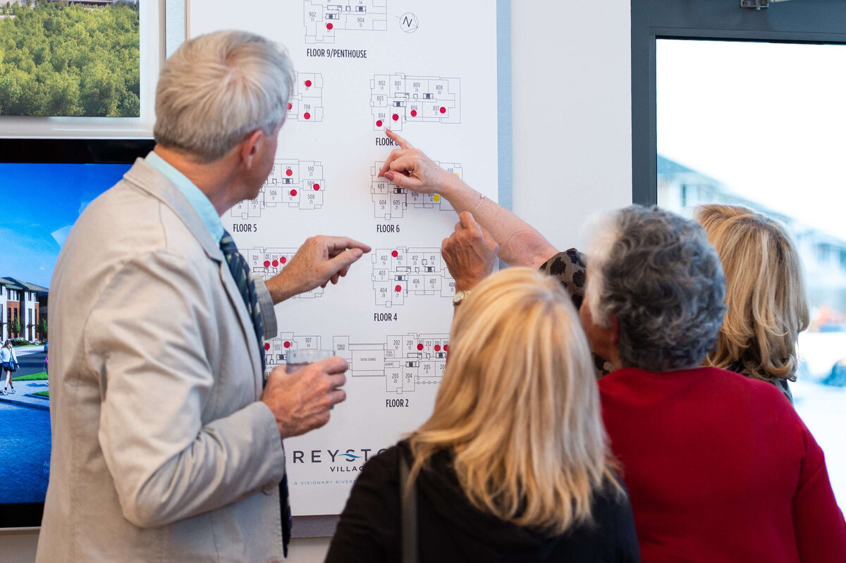 Ottawa event photography showing guests of the eQ groundbreaking event looking at model home plans.  Captured by JEMMAN Photography COMMERCIAL