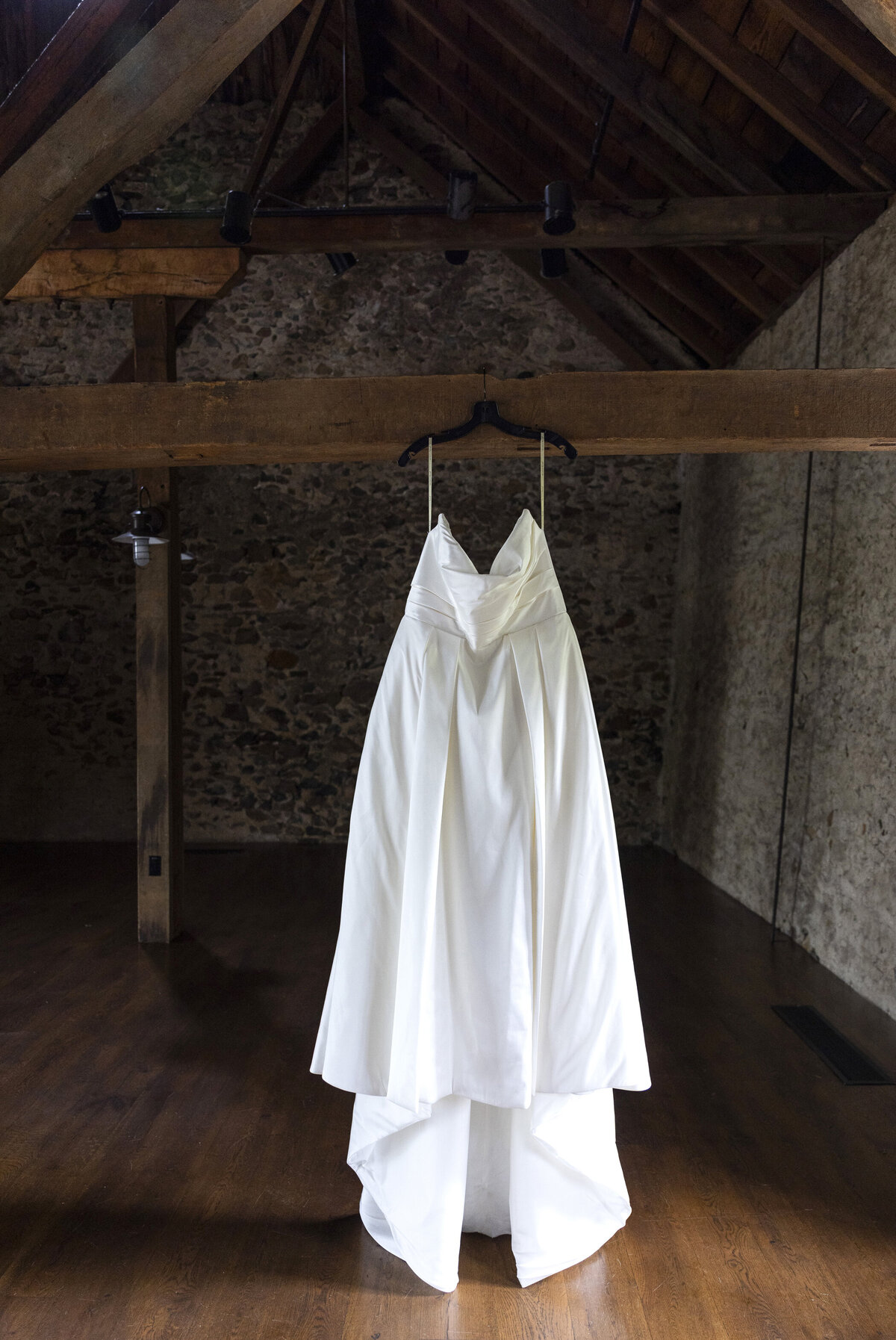 Wedding gown hanging from rafter at Tyler Arboretum in Pennsylvania