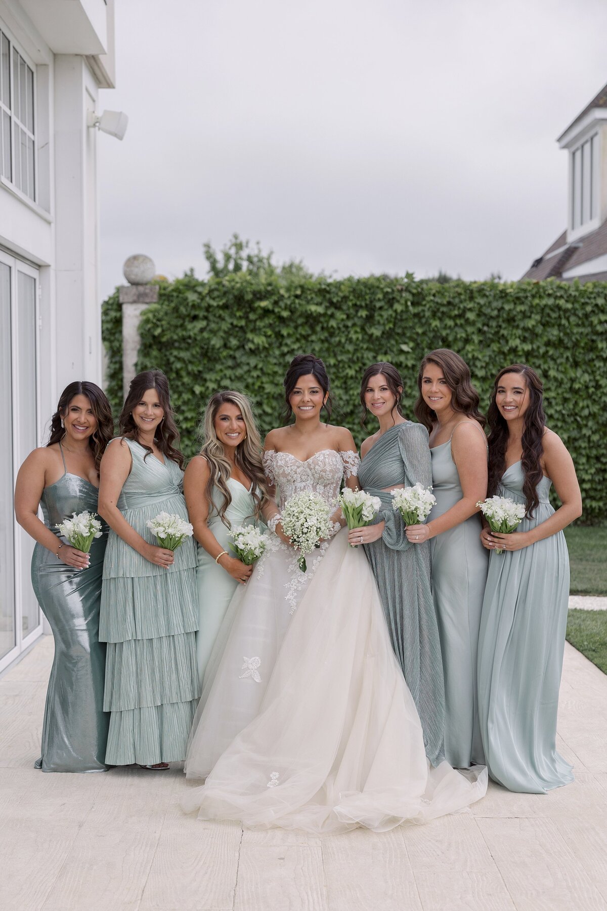 Bride surrounded by bridesmaids in teal dresses at Belle Mer Newport.