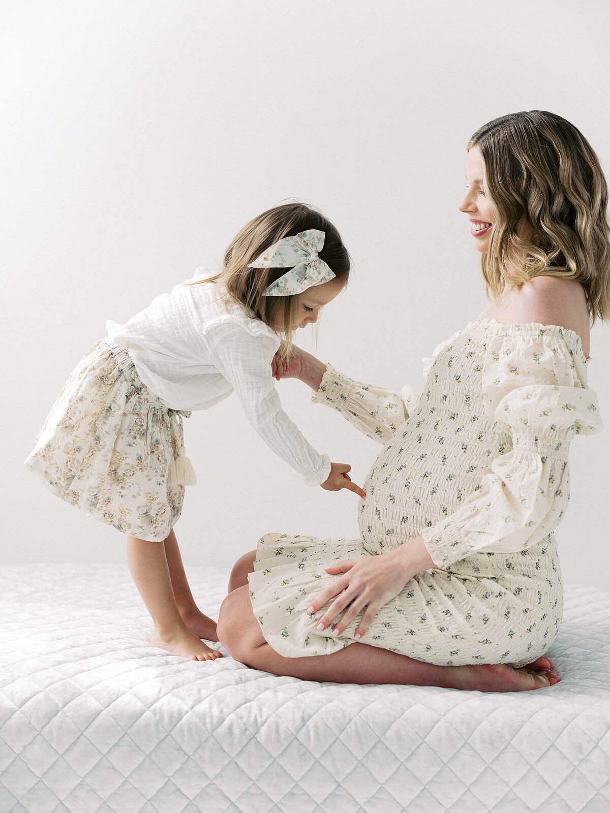 toddler girl points to mom's pregnant belly photographed by seattle family and maternity photographer Jacqueline Benét 