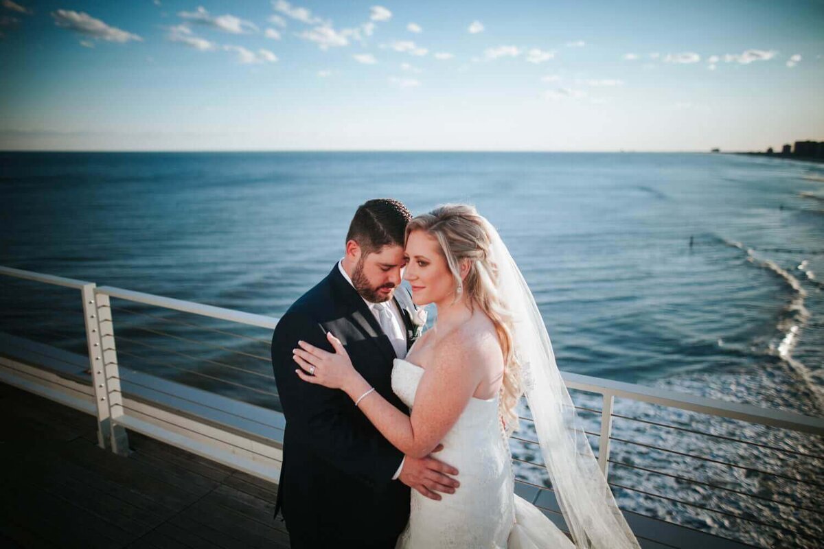 Bride and Groom embracing each other at Atlantic City next to the beach.