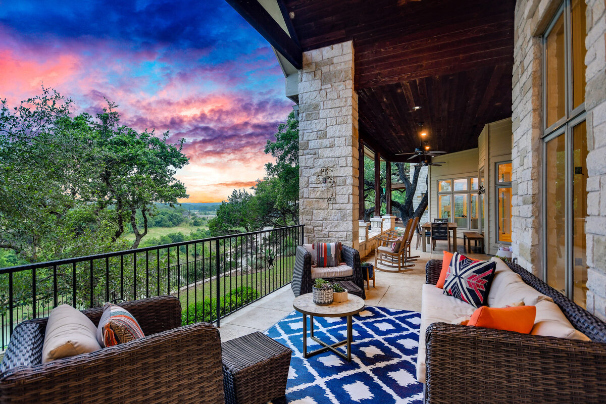 Exterior sitting area with blue rug and decorative pillows