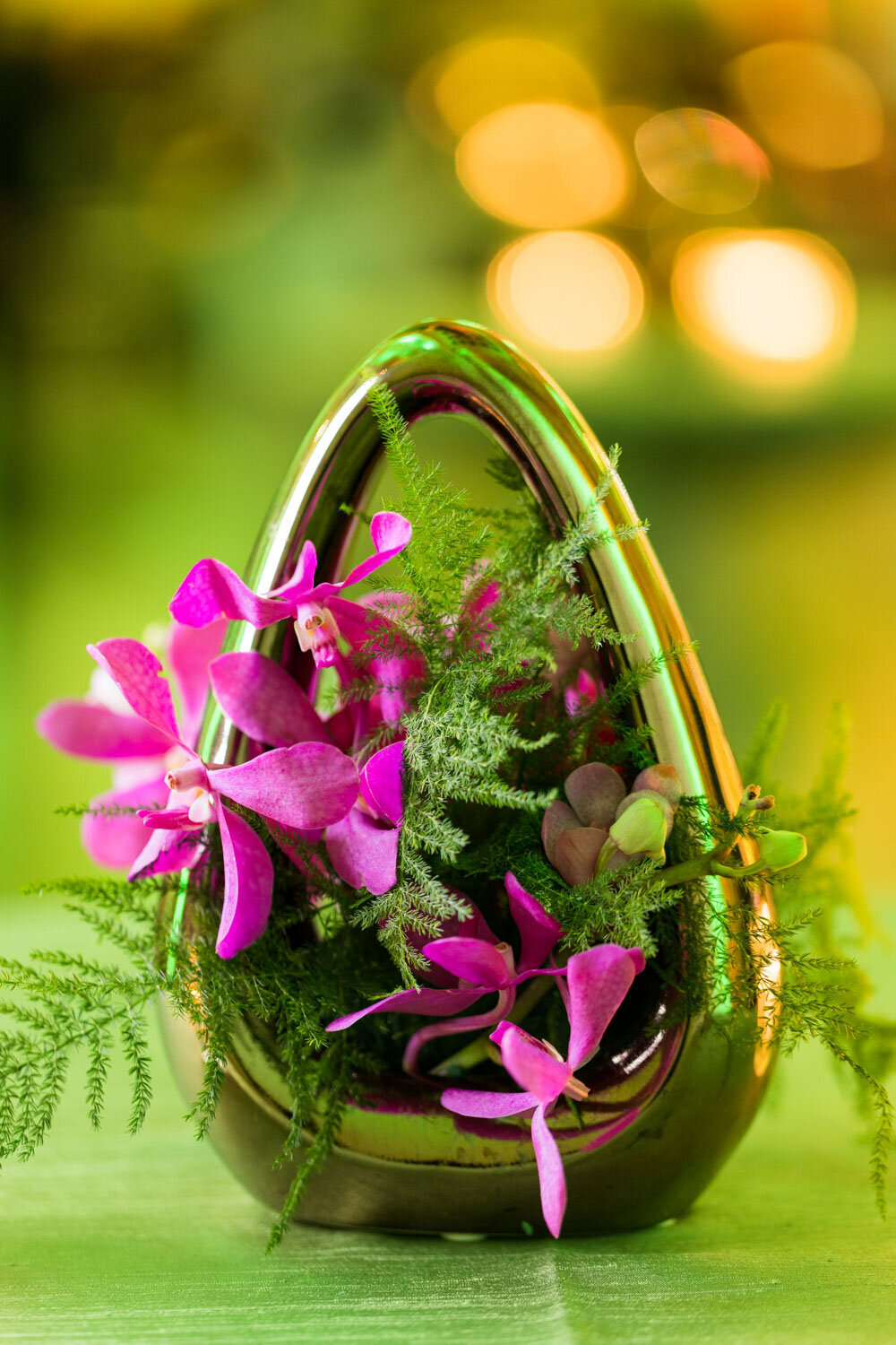 Modern floral arrangement with orchids in a metallic vase