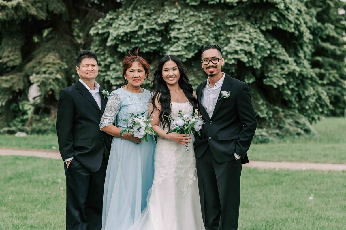 Bride and groom stand with grooms parents.
