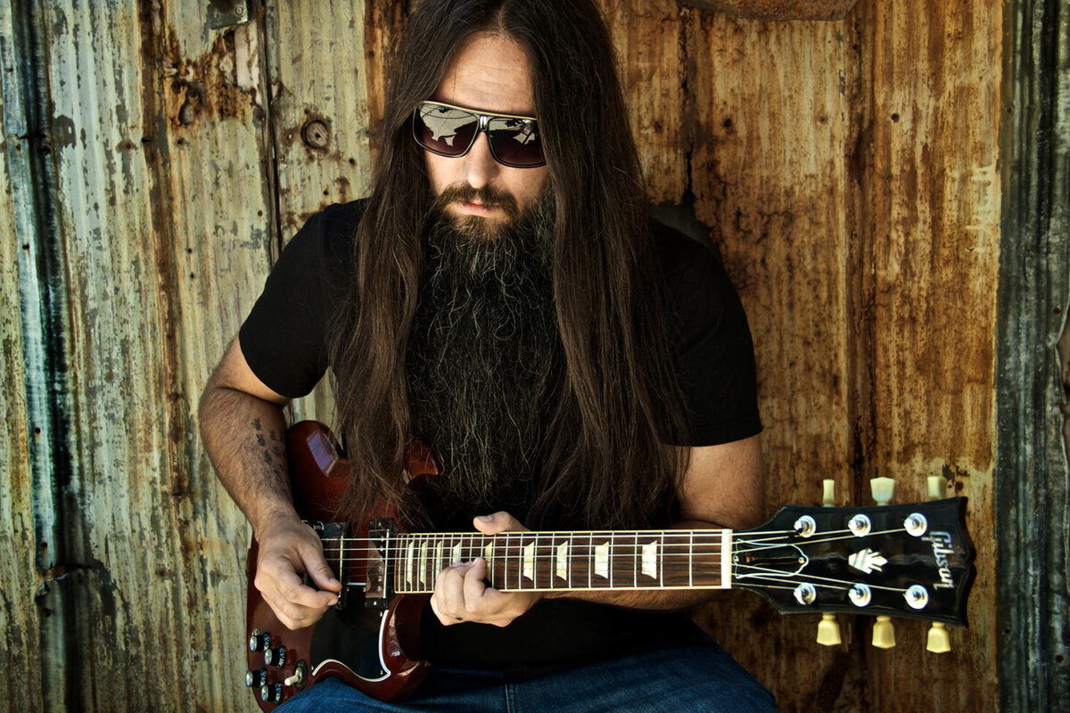 Musician portrait Rick Jackett Finger Eleven sittings against rusted wall strumming guitar Just Play Something Gallery