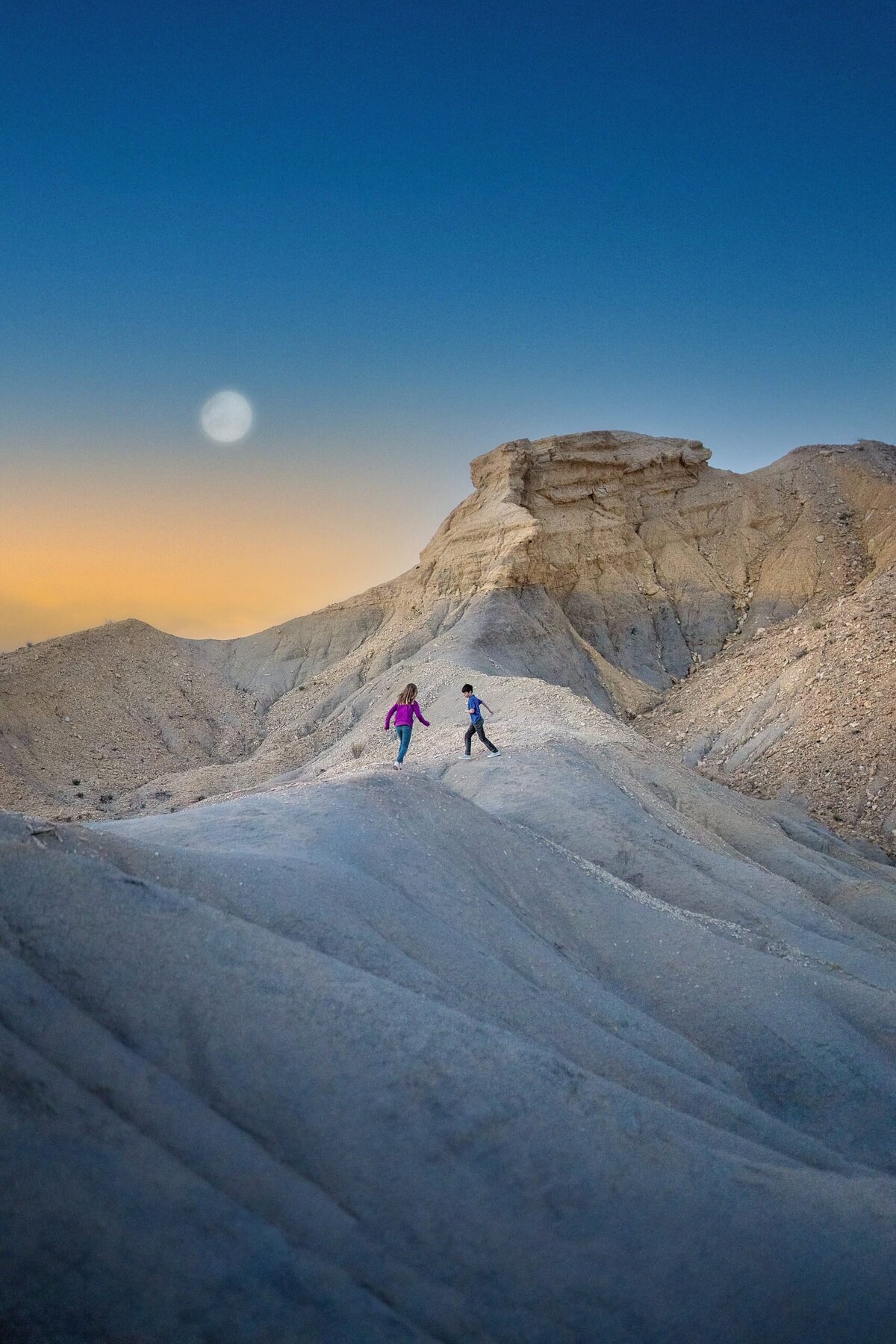 Two children run along the dessert mountains in Big Bend National Park.