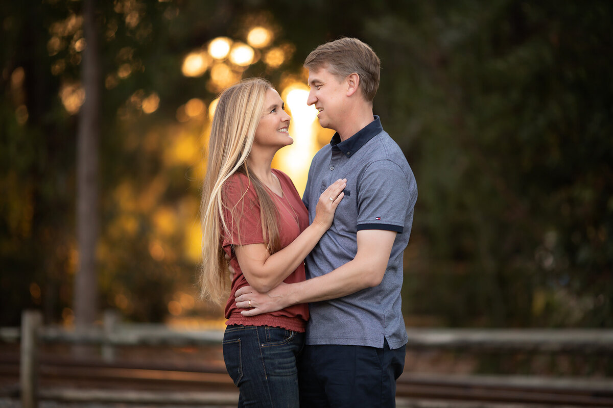 A couple shares a tender moment, captured by a Dallas family portrait photographer in a beautiful outdoor setting.