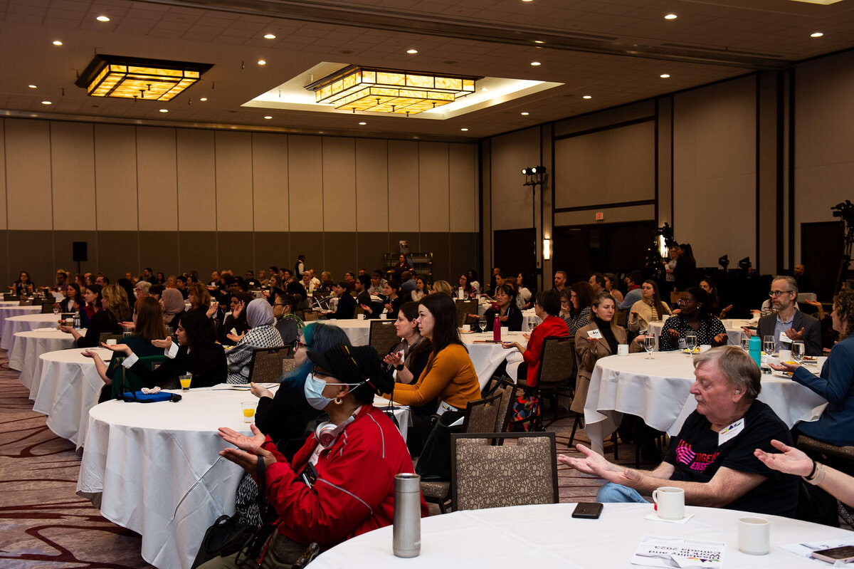 Ottawa event photography showing a room full of attendees clapping.  Captured by JEMMAN Photography COMMERCIAL