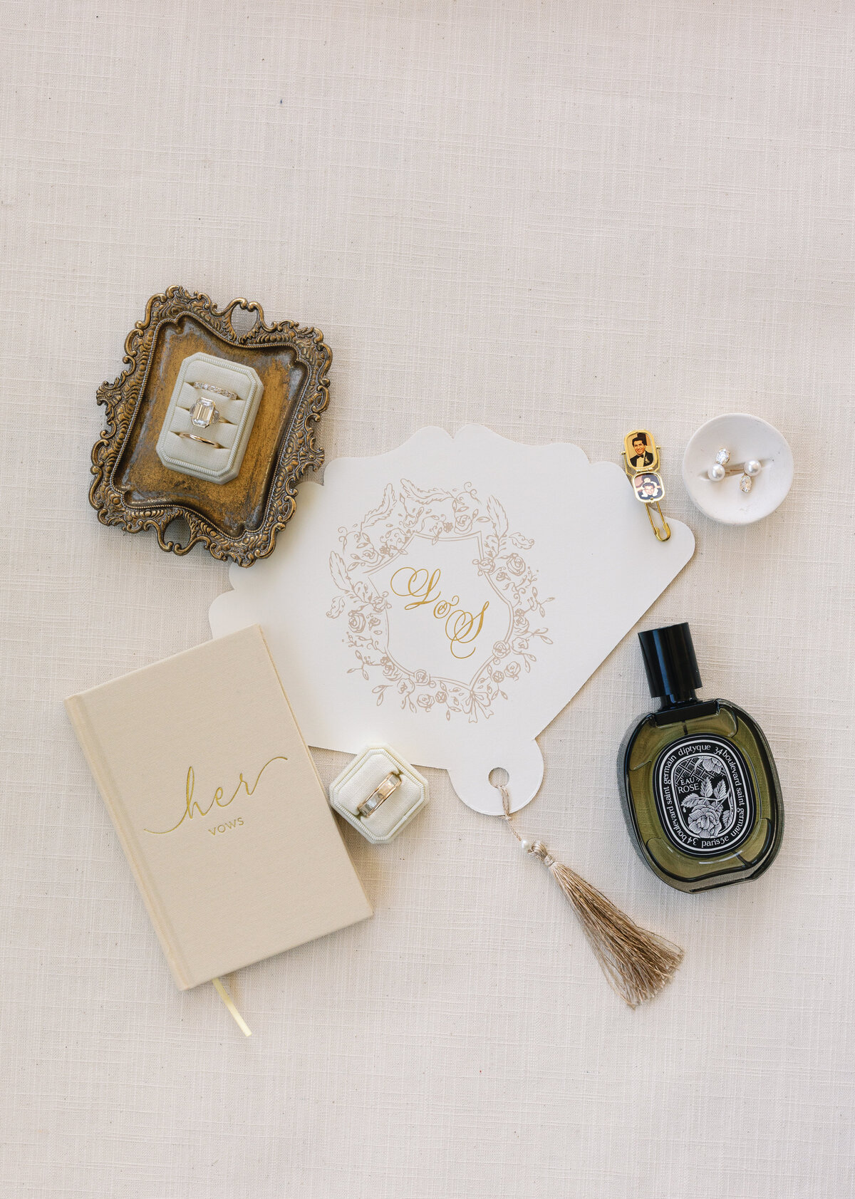 Marblehead wedding, luxury wedding, their flat lay with perfume, and vow book, rings, and a customized fan print