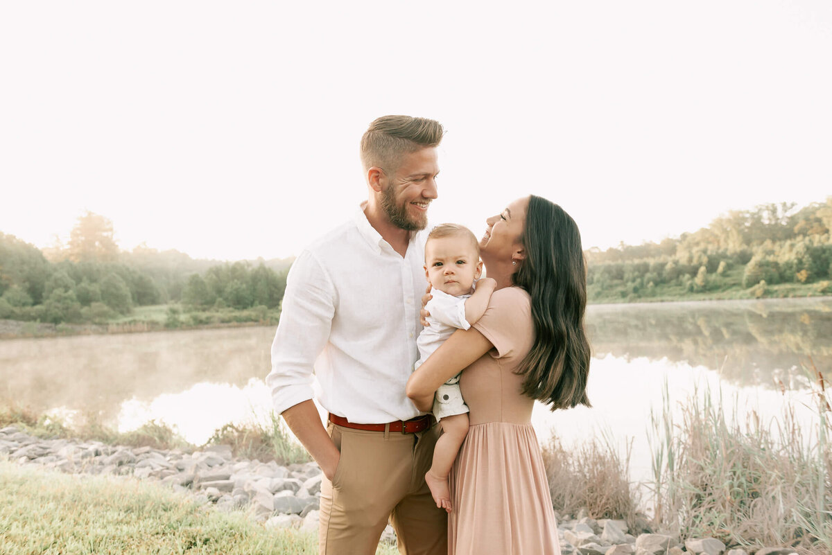 candid photo of parents holding a one year old in raleigh