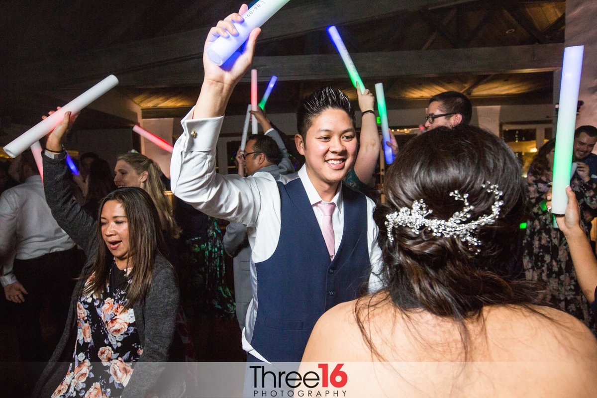 Groom dances with his Bride and others on the dance floor during wedding reception