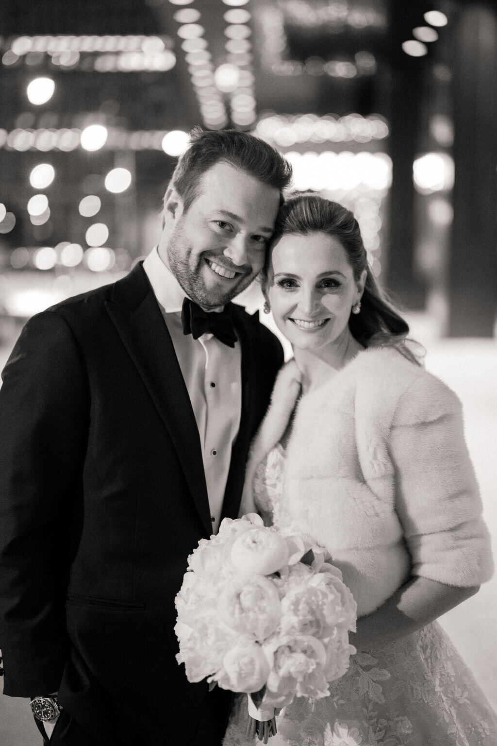 Up close black and white photo of the bride and groom smiling. 