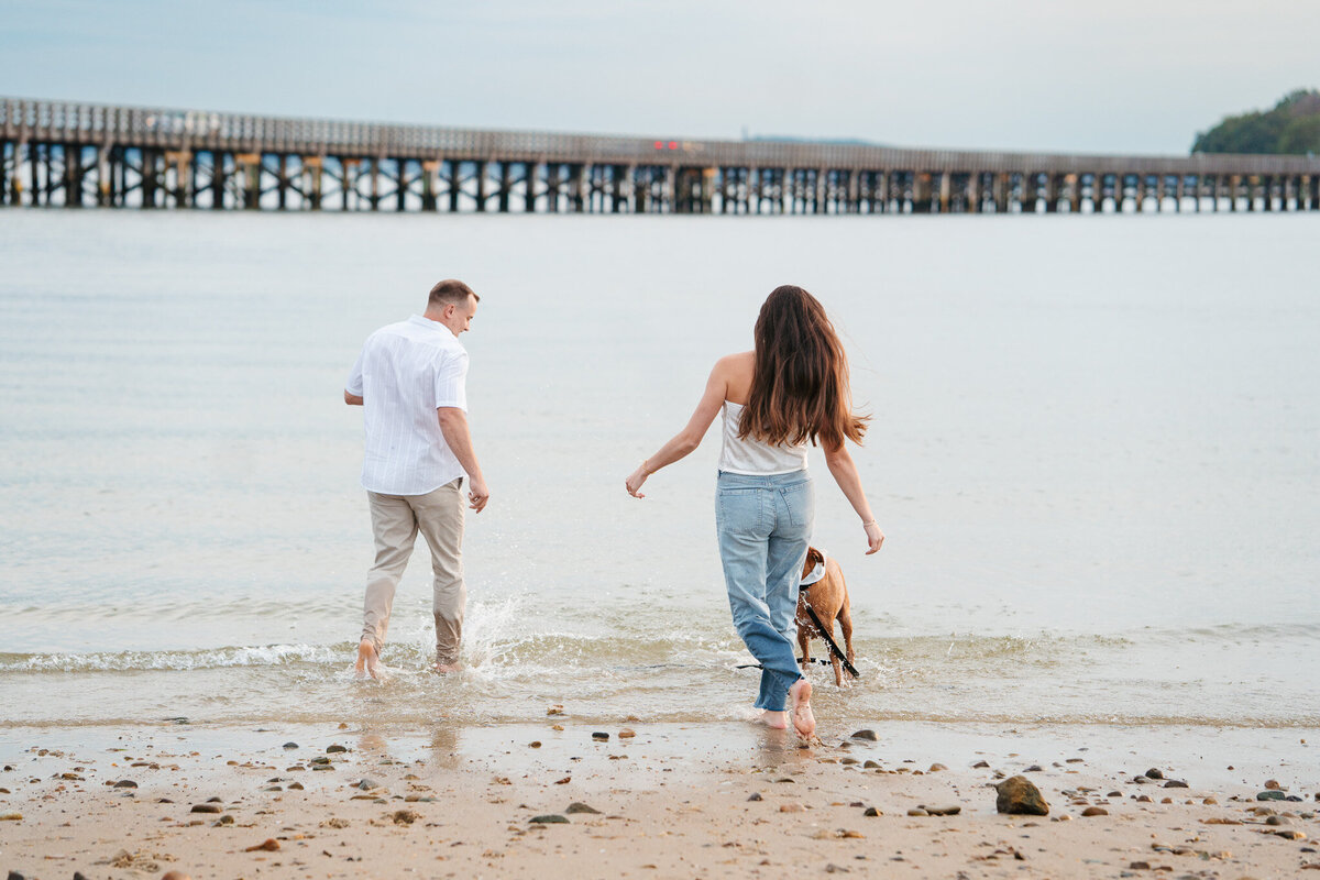 Romantic Duxbury Beach engagement portraits including playful shots with the couple’s dog