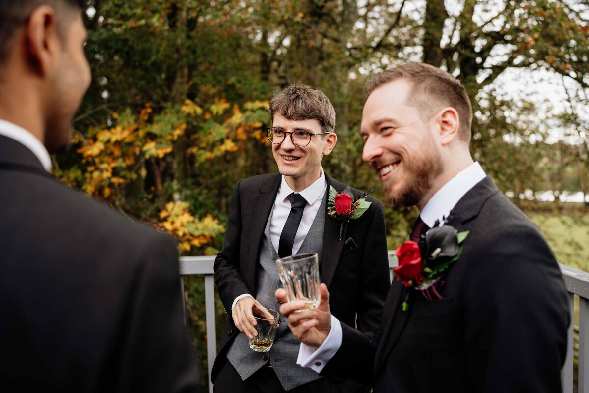 A wedding guests is photographed having a candid drink.