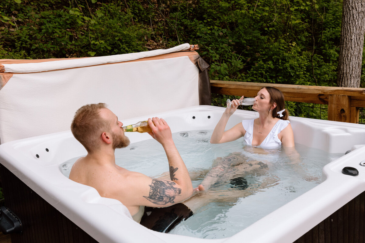 Couple drinking in a hot tub.
