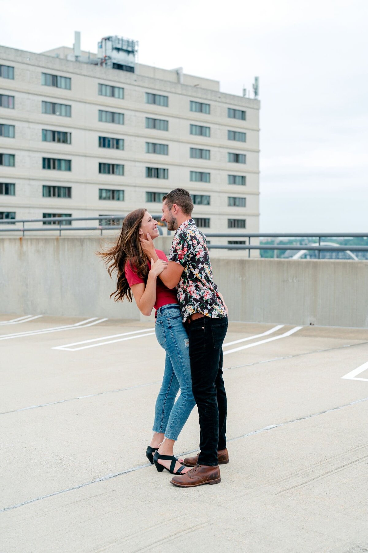 couple-embracing-wind-blowing-rooftop-engagement