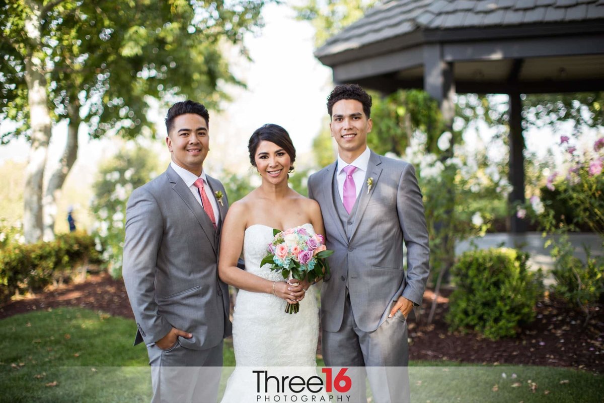 Bride poses with her brothers at the ceremony