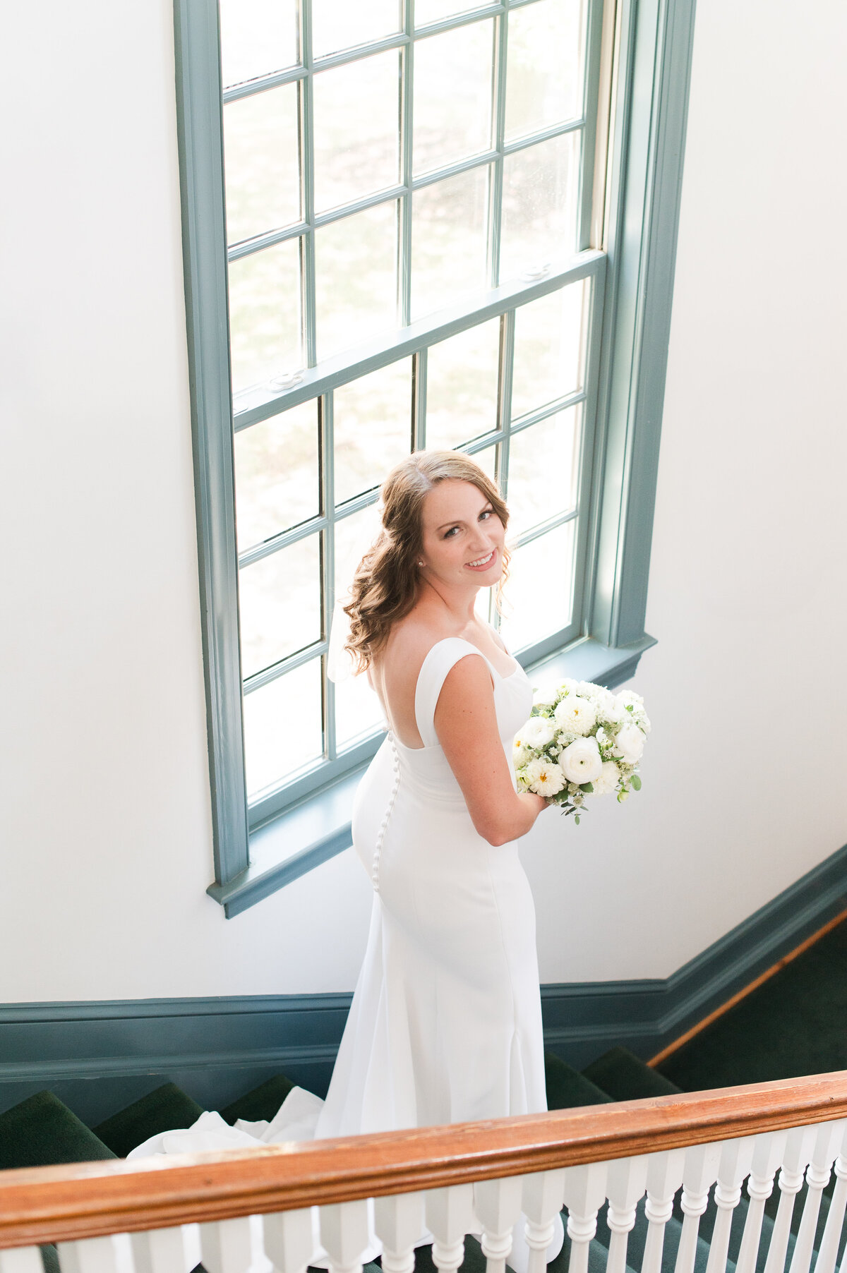 Bride on staircase holding bouquet