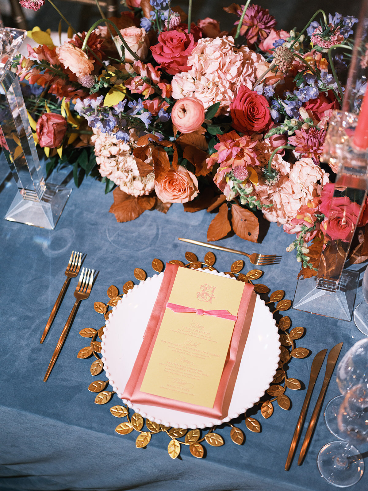 Wedding table with dinnerwares that has menu calligraphy