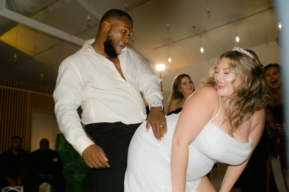 bride dancing on her husband during the reception
