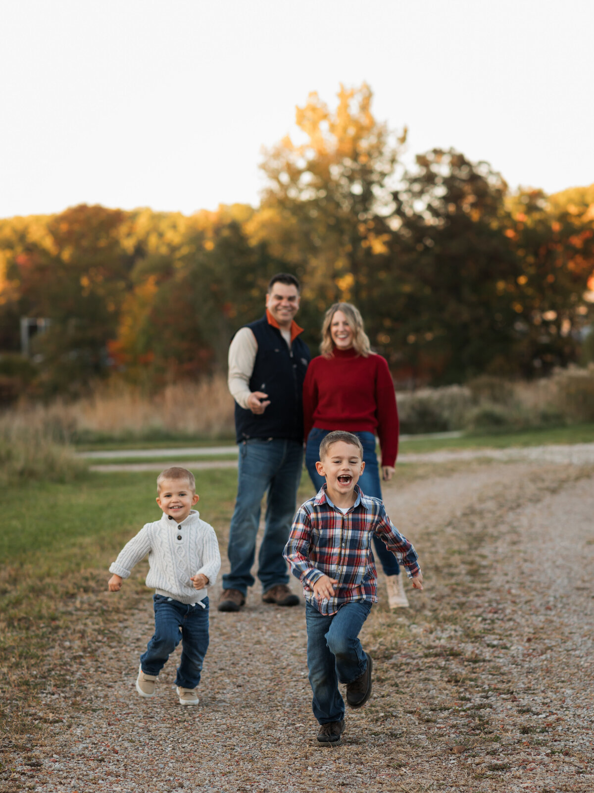 two brothers running in park with parents for family photos cleveland family photography