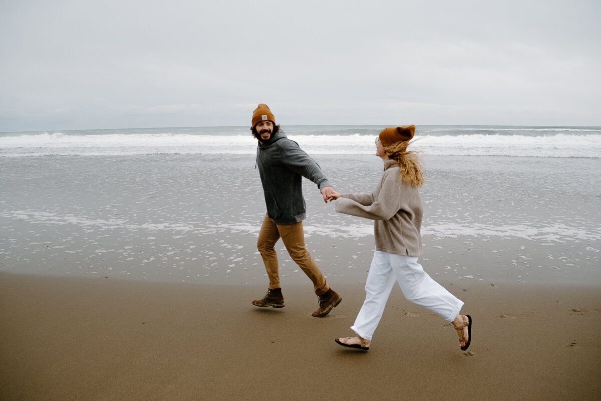 A couple runs along the beach in Lincoln City, Oregon