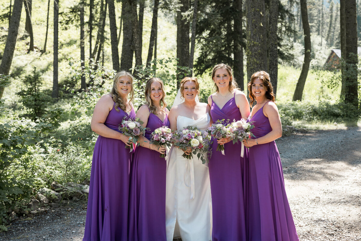 Bride and bridesmaids standing among pine trees at The Woodlands at Cottonwood Canyon.