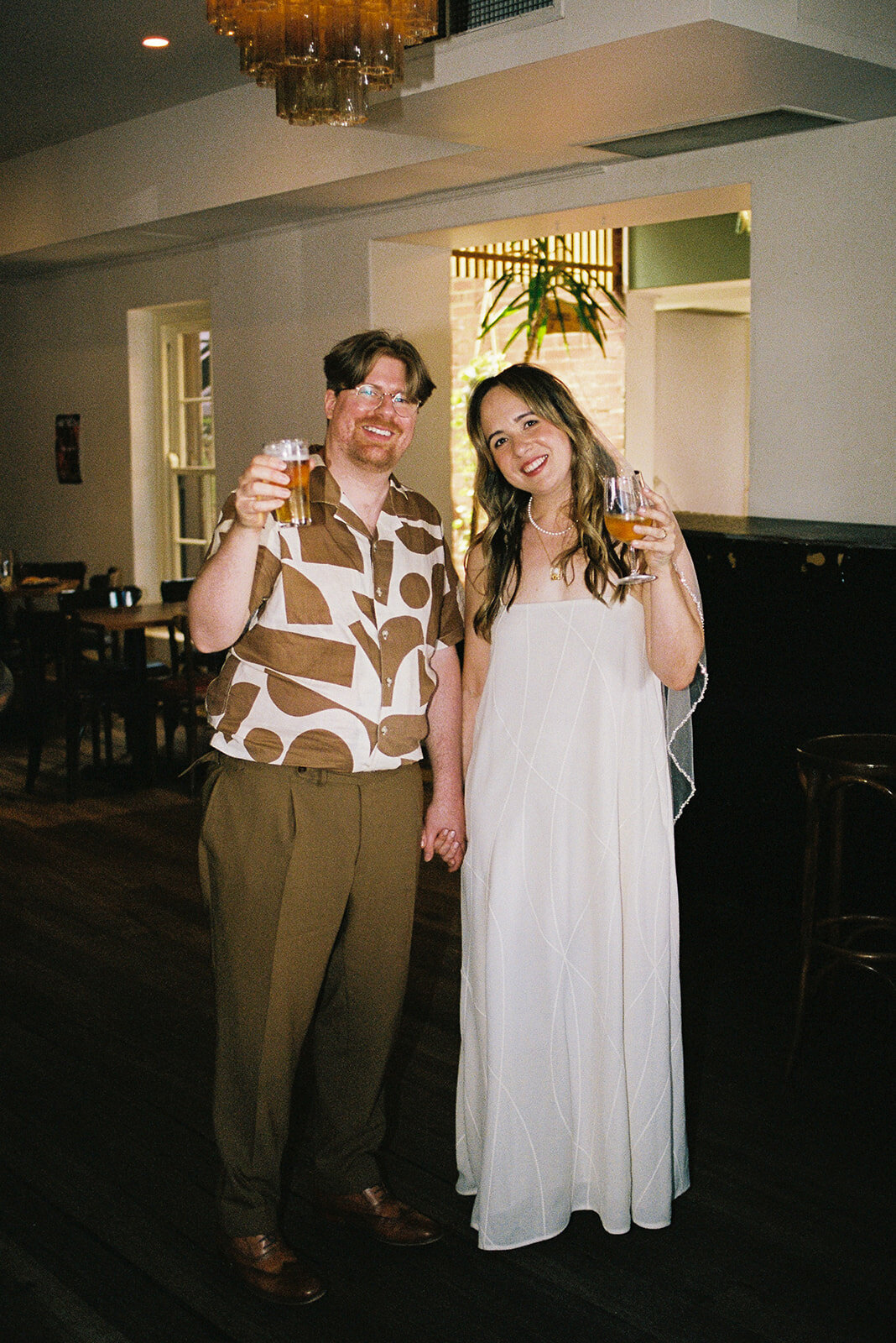 Couple sharing a quiet, intimate moment together at a cozy Melbourne bar during their micro-wedding, captured on 35mm film