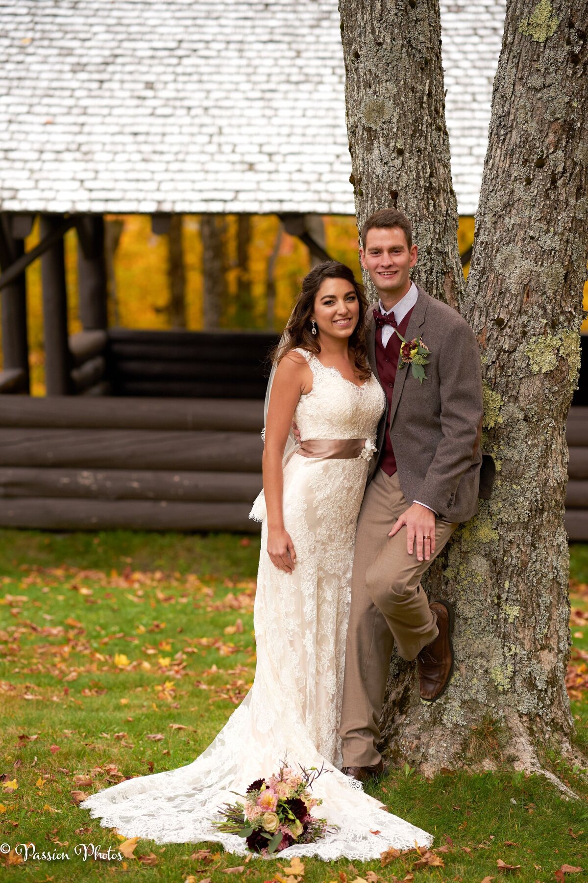 A couple leans against a tree, enjoying a serene moment together. Their relaxed posture and the natural backdrop create a candid and intimate atmosphere.