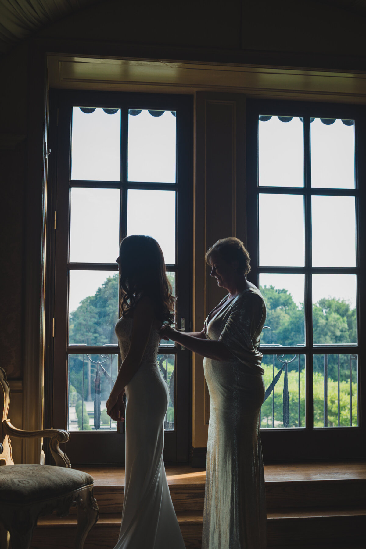 bride getting help with her dress at Oheka Castle