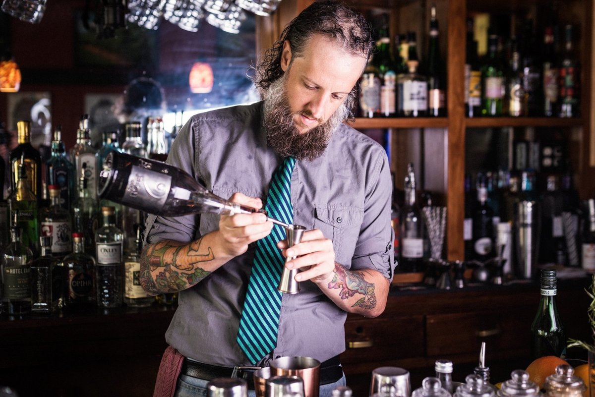 Advertising portrait photograph of a bartender mixing a cocktail