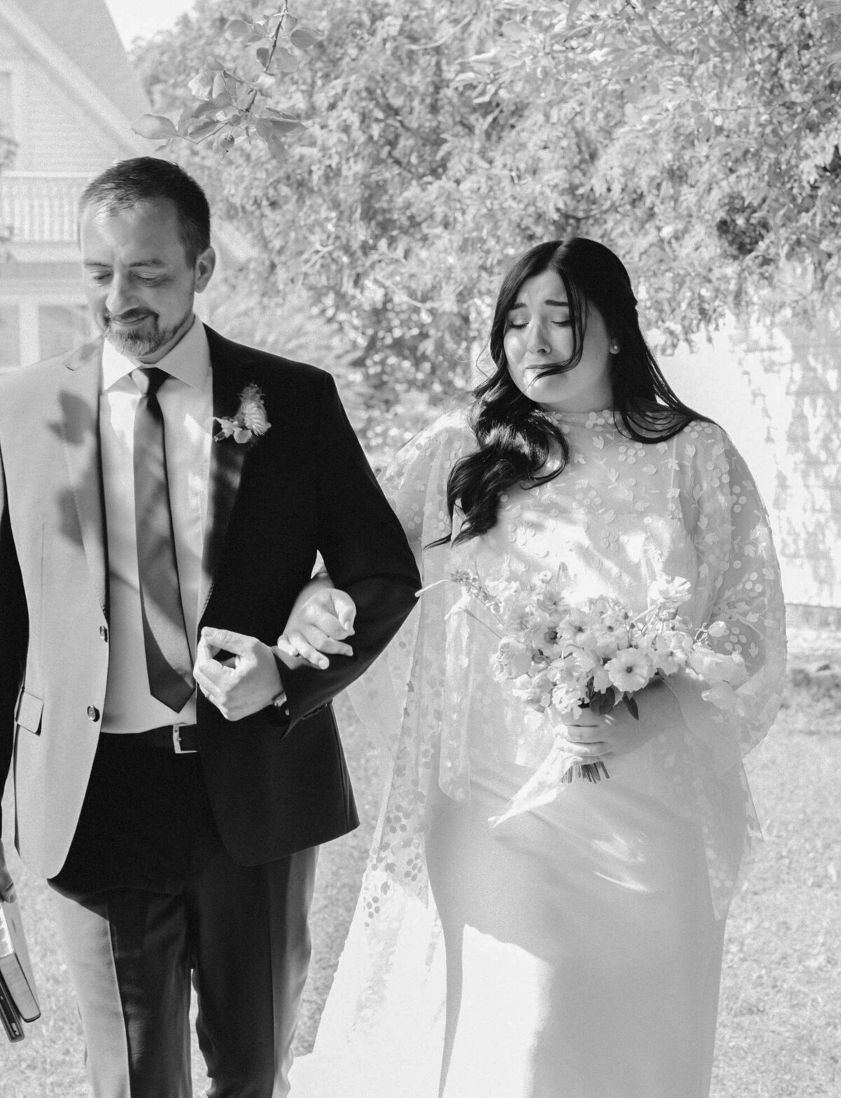emotional bride walks down aisle at Glass House Community, West Michigan wedding venue