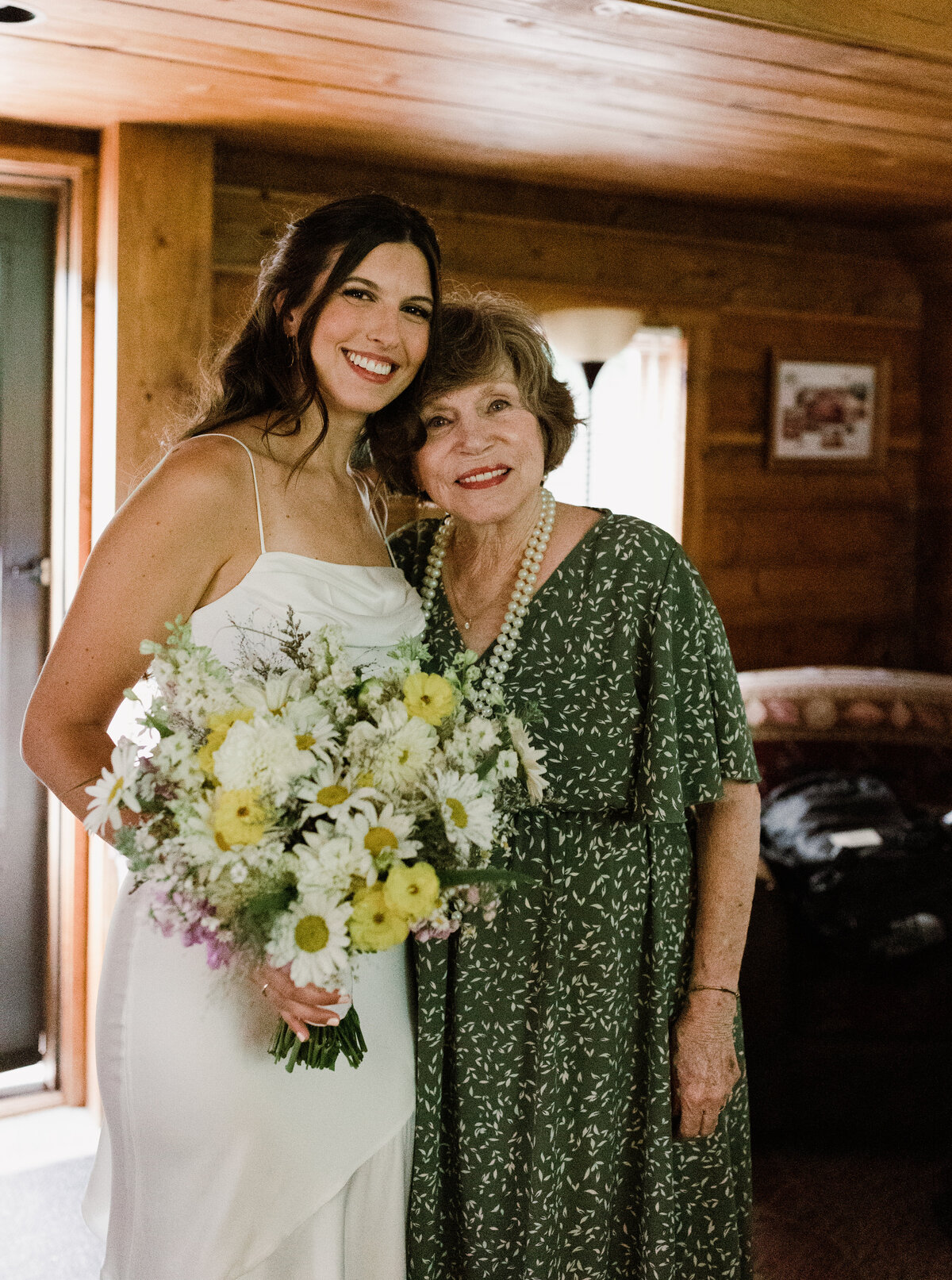 Bride standing next to woman in floral green dress at Dallenbach Ranch Colorado Wedding