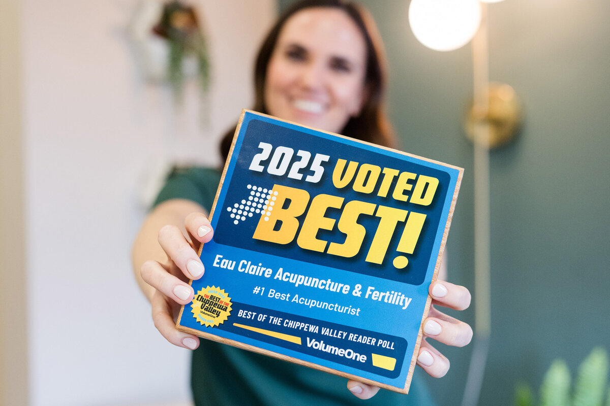 Jessica wearing a white blazer, smiling as she writes in her planner