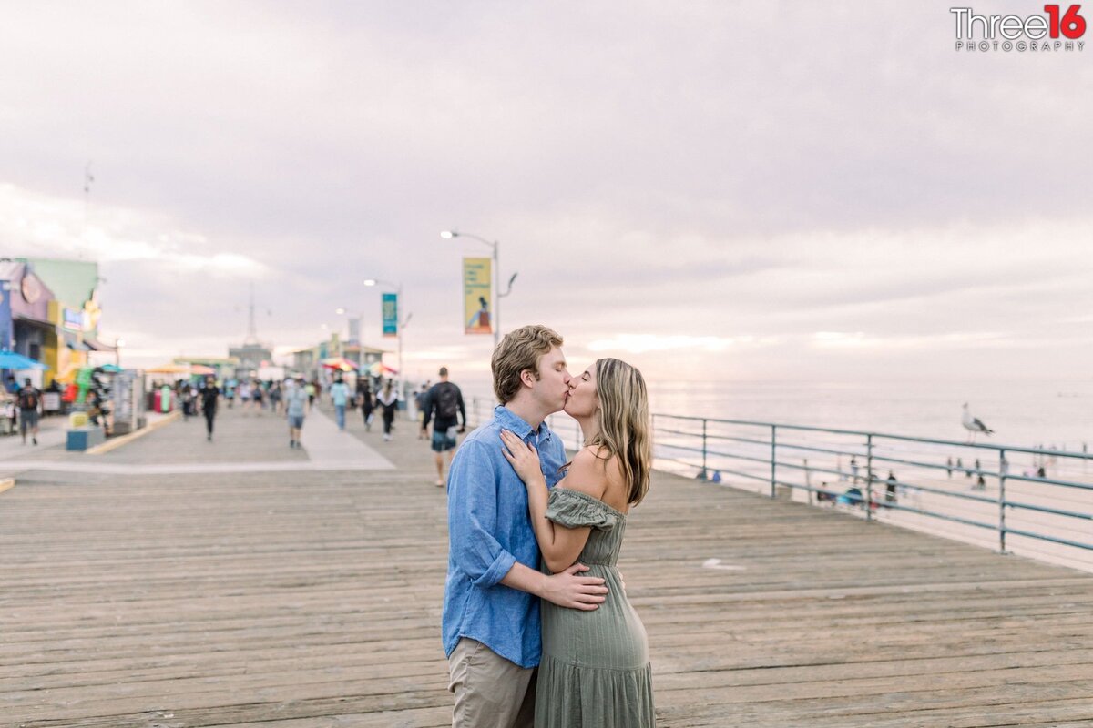 Engaged couple share a kiss on the Santa Monica Pier