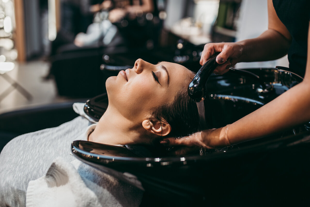woman getting hair shampoos in salon